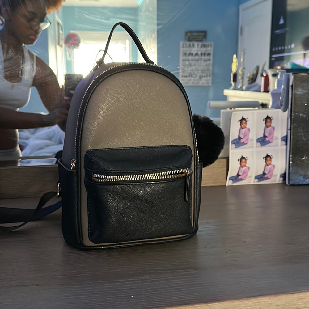 This is a small hand bag with black straps and fix puff ball, brand new